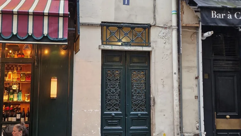 Rue parisienne commerçante avec terrasse de bistrot, secteur recherché pour l'investissement locatif