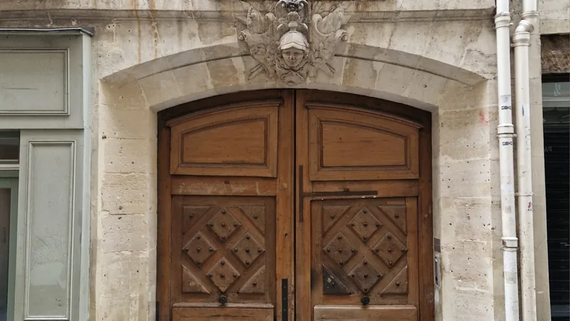 Porte cochère en bois et mascaron sculpté, immeuble parisien détenu en SCI familiale